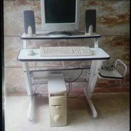 کامپیوتر و میز کامپیوتر بامتعلقات داخل عکس